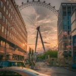 ferris wheel near building during sunset