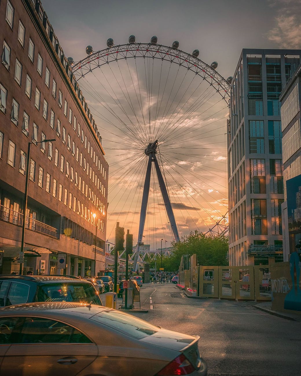 ferris wheel near building during sunset